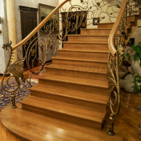 Монолитная лестница с кованым ограждением и дубовыми ступенями